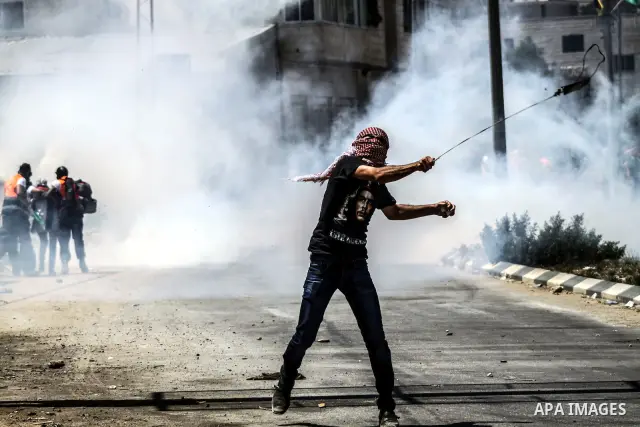 A Palestinian protester throws stones at Israeli soldiers during clashes at the entrance to Ofer prison, near the West Bank city of Ramallah, on June 5, 2012 following a demonstration to mark "Naksa Day", the 44th annive...