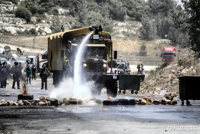Israeli truck spray foul smelling water towards Palestinian protesters during clashes at the entrance to Ofer prison, near the West Bank city of Ramallah, on June 5, 2012 following a demonstration to mark "Naksa Day", th...