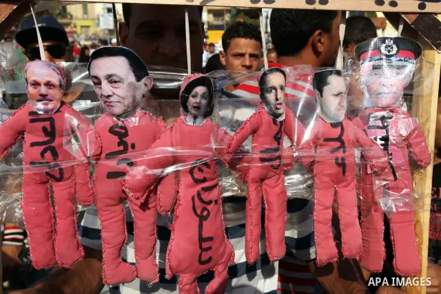 An Egyptian holds pictures against the Supreme Council of the Armed Forces (SCAF) near Tahrir Square during a demonstration in Cairo June 5, 2012. Activists urged Egyptians to turn out for a big protest on Tuesday to rec...