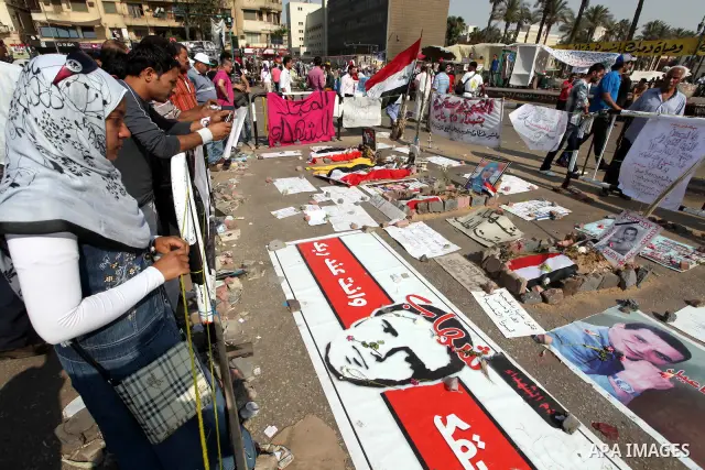 Egyptians protesters stand in front pictures of Revolution martyrs during a demonstration at Tahrir square in Cairo June 5, 2012. Activists urged Egyptians to turn out for a big protest on Tuesday to reclaim a revolt the...