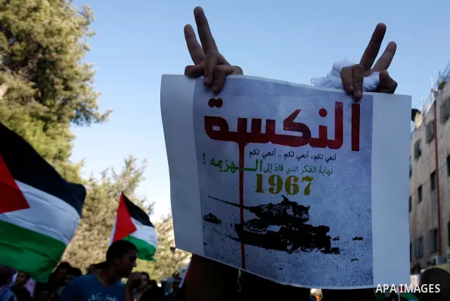 Palestinian protester holds poster during a demonstration marking the 'Naksa Day' at the Damascus Gate on 05 June 2012. Naksa Day is the annual day of commemoration for the Palestinian people of the displacement that acc...