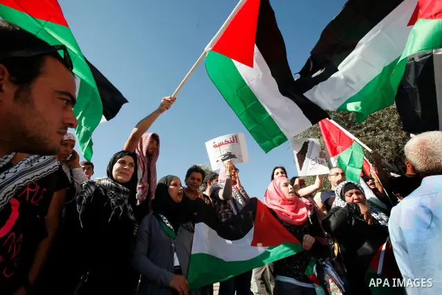 Palestinian protesters hold flags during a demonstration marking the 'Naksa Day' at the Damascus Gate on 05 June 2012. Naksa Day is the annual day of commemoration for the Palestinian people of the displacement that acco...