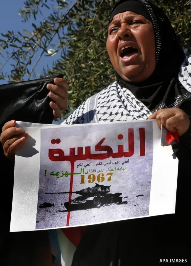 Palestinian protester holds poster during a demonstration marking the 'Naksa Day' at the Damascus Gate on 05 June 2012. Naksa Day is the annual day of commemoration for the Palestinian people of the displacement that acc...