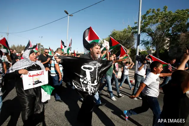 Palestinian protesters hold flags during a demonstration marking the 'Naksa Day' at the Damascus Gate on 05 June 2012. Naksa Day is the annual day of commemoration for the Palestinian people of the displacement that acco...