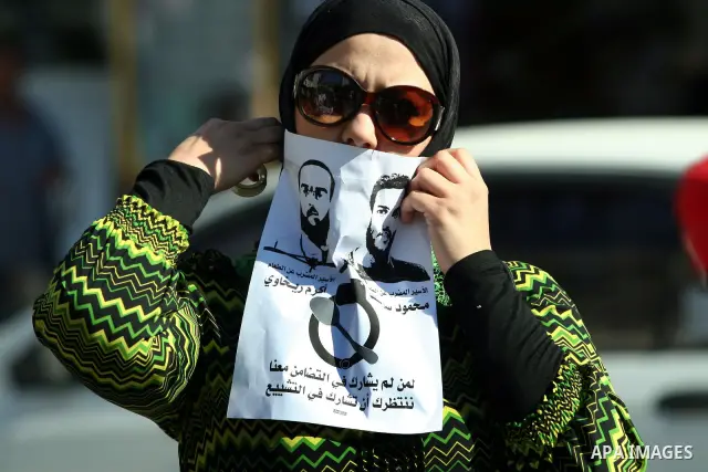 Palestinian protestors hold pictures of Palestinian prisoners Mahmoud al-Sarsak and Akram al-Rikhawi, whose are still refusing food for 80 days after a deal was made to end a mass prisoner hunger strike, during a demonst...