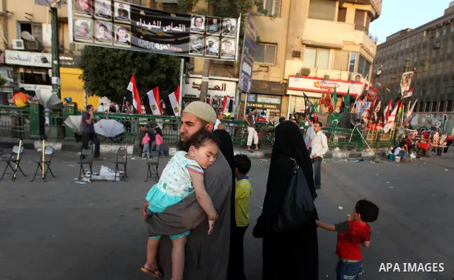 Egyptian family walk at Tahrir Square during a demonstration in Cairo on June 6, 2012 to protest against verdicts handed down in ex-president Hosni Mubarak's murder trial. Mubarak and his interior minister Habib al-Adly...