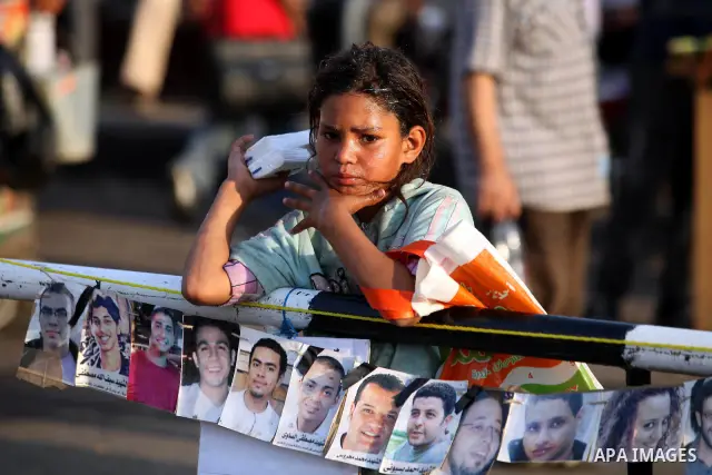 Egyptian girl stands near pictures of killings demonstrators, during a demonstration in Cairo's landmark Tahrir Square on June 6, 2012 to protest against verdicts handed down in ex-president Hosni Mubarak's murder trial....