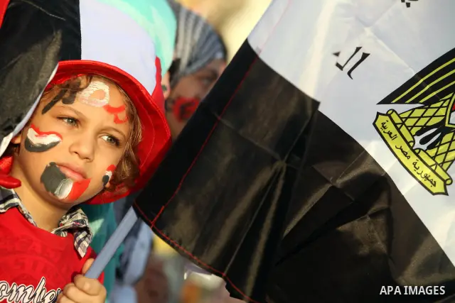 Egyptian girl wears a hat decorated with national flag during a demonstration in Cairo's landmark Tahrir Square on June 6, 2012 to protest against verdicts handed down in ex-president Hosni Mubarak's murder trial. Mubara...