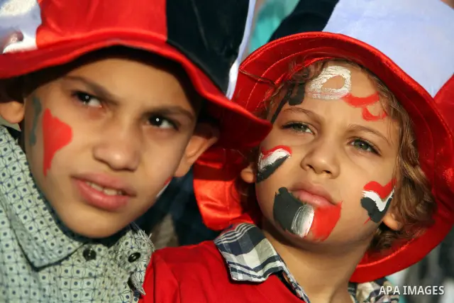 Egyptian kids wear hats decorated with national flag during a demonstration in Cairo's landmark Tahrir Square on June 6, 2012 to protest against verdicts handed down in ex-president Hosni Mubarak's murder trial. Mubarak...