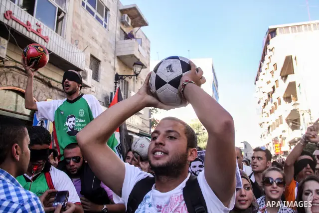 Palestinian youth play football in the streets of Ramallah during a rally solidarity with Palestinian prisoner Mahmoud Al-Sarsak who is still refusing food after a deal was made to end a mass prisoner hunger strike, on 0...