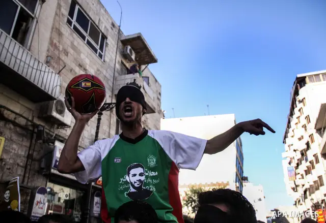 Palestinian youth play football in the streets of Ramallah during a rally solidarity with Palestinian prisoner Mahmoud Al-Sarsak who is still refusing food after a deal was made to end a mass prisoner hunger strike, on 0...