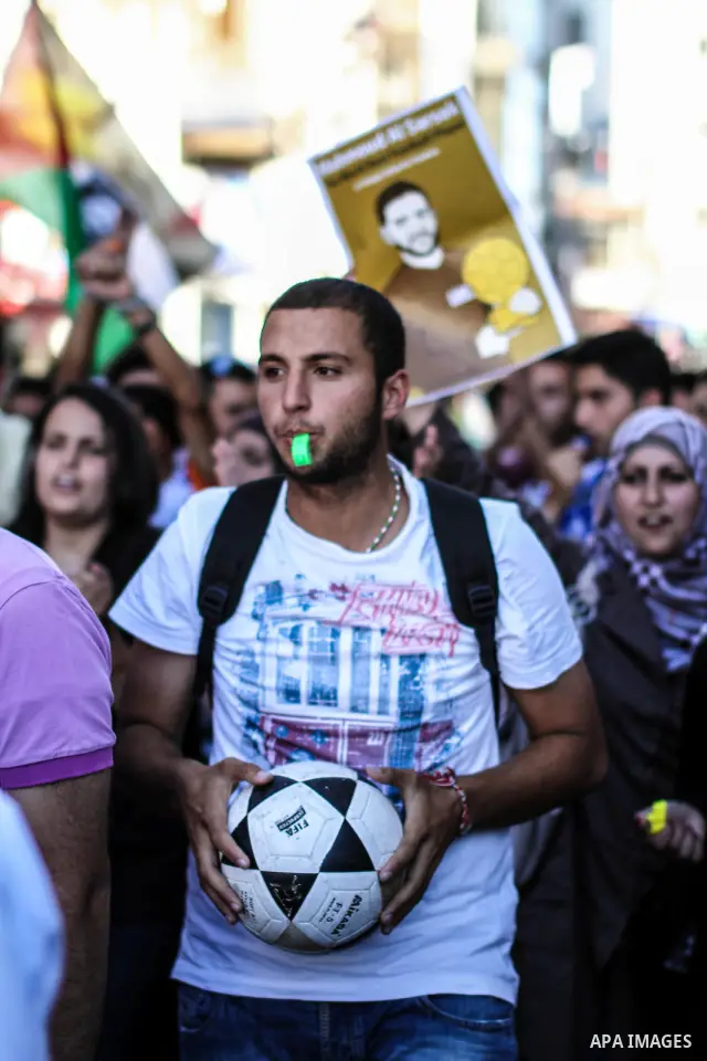 Palestinian youth play football in the streets of Ramallah during a rally solidarity with Palestinian prisoner Mahmoud Al-Sarsak who is still refusing food after a deal was made to end a mass prisoner hunger strike, on 0...