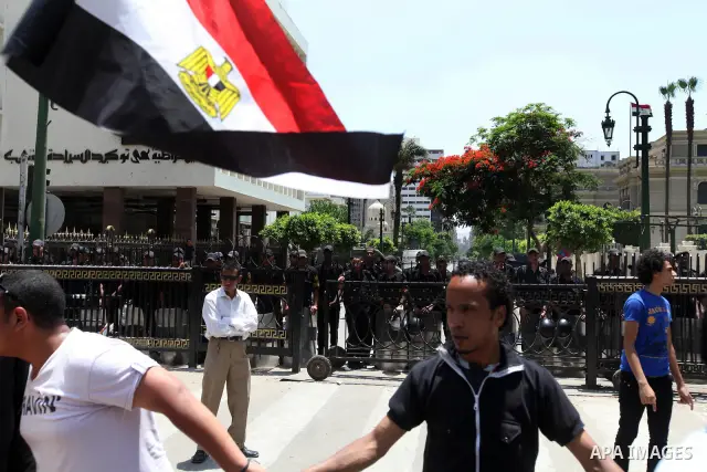 Egyptian protesters wave national flags during a demonstration against presidential candidate Ahmed Shafiq in central Cairo's Tahrir Square, as hundreds of people gathered after the Friday noon prayer on June 8, 2012 in...