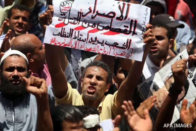 Egyptian protesters wave national flags during a demonstration against presidential candidate Ahmed Shafiq in central Cairo's Tahrir Square, as hundreds of people gathered after the Friday noon prayer on June 8, 2012 in...