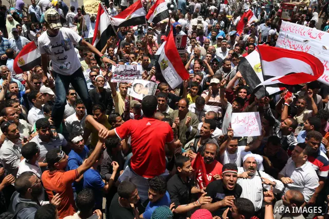 Egyptian protesters wave national flags during a demonstration against presidential candidate Ahmed Shafiq in central Cairo's Tahrir Square, as hundreds of people gathered after the Friday noon prayer on June 8, 2012 in...