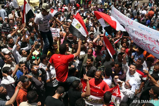 Egyptian protesters wave national flags during a demonstration against presidential candidate Ahmed Shafiq in central Cairo's Tahrir Square, as hundreds of people gathered after the Friday noon prayer on June 8, 2012 in...