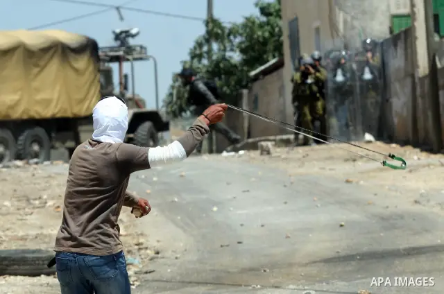 Palestinian protesters throw stones toward Israeli border police during clashes after a demonstration against the nearby Jewish settlement of Kdumim, in the West Bank village of Kfar Kadum, near Nablus June 8, 2012. Phot...