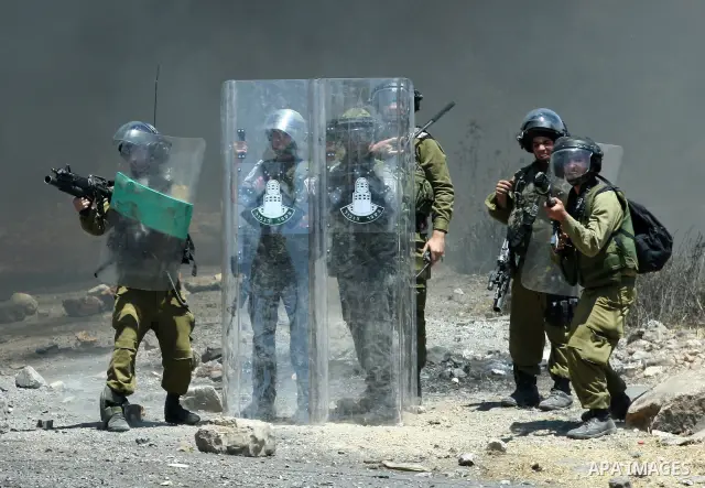 Israeli border police fire tear gas canisters during clashes with stone-throwing Palestinian protesters at a demonstration against the nearby Jewish settlement of Kdumim, in the West Bank village of Kfar Kadum, near Nabl...