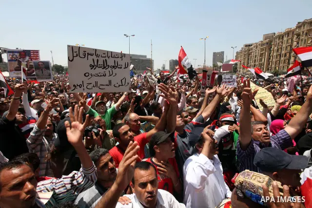 Egyptian protesters wave national flags during a demonstration against presidential candidate Ahmed Shafiq in central Cairo's Tahrir Square, as hundreds of people gathered after the Friday noon prayer on June 8, 2012 in...