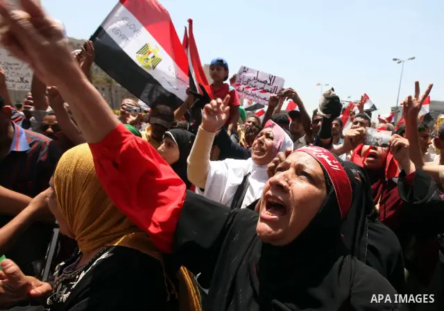 Egyptian protesters wave national flags during a demonstration against presidential candidate Ahmed Shafiq in central Cairo's Tahrir Square, as hundreds of people gathered after the Friday noon prayer on June 8, 2012 in...