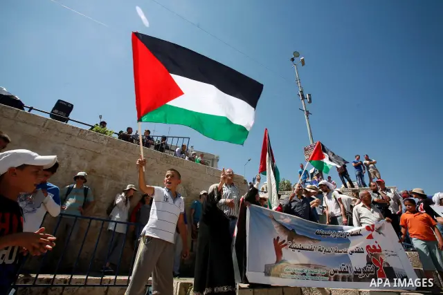 Palestinians hold national flag and shout slogans during a protest against continuing of 'Judaization of Jerusalem' by Jewish settlers and confiscating Palestinian lands at Damascus gate after Friday prayer in east jerus...