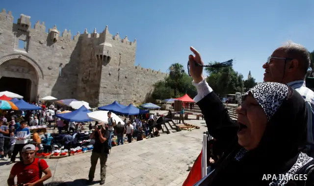 Palestinians hold national flag and shout slogans during a protest against continuing of 'Judaization of Jerusalem' by Jewish settlers and confiscating Palestinian lands at Damascus gate after Friday prayer in east jerus...