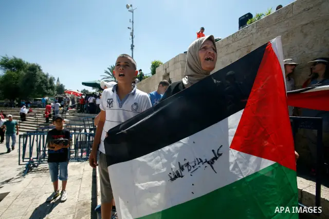 Palestinians hold national flag and shout slogans during a protest against continuing of 'Judaization of Jerusalem' by Jewish settlers and confiscating Palestinian lands at Damascus gate after Friday prayer in east jerus...