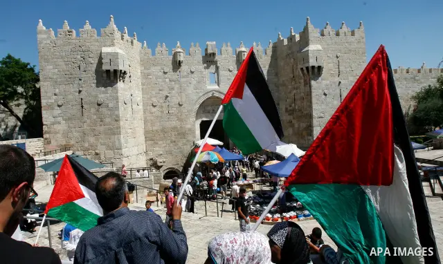 Palestinians hold national flag and shout slogans during a protest against continuing of 'Judaization of Jerusalem' by Jewish settlers and confiscating Palestinian lands at Damascus gate after Friday prayer in east jerus...