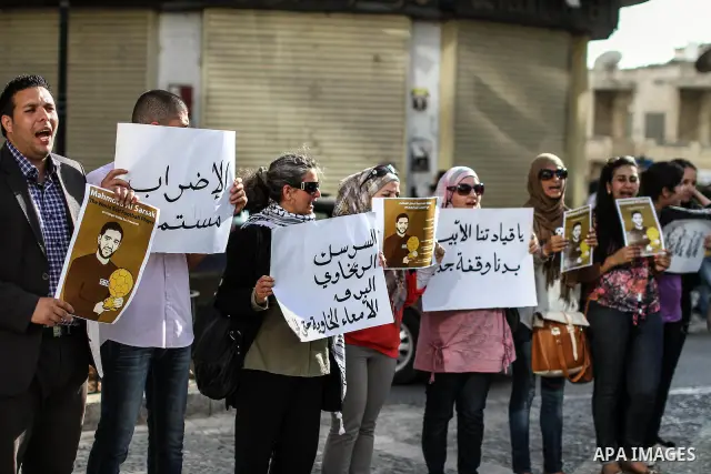 Palestinians hold banners and call the drivers to blow their horns during a demonstration solidarity with Palestinian prisoners whose still on hunger strike in Israeli jails, in the West Bank city of Ramallah, on 10 June...