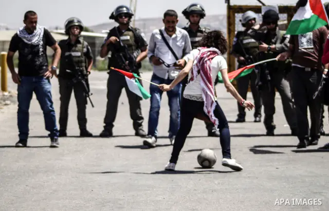 Israeli police keep guard as Palestinian protestors play football in front of Ofer prison, near the city of Ramallah, in solidarity with jailed Palestinian football player Mahmud Sarsak and prisoners Akram Rikhawi and Sa...