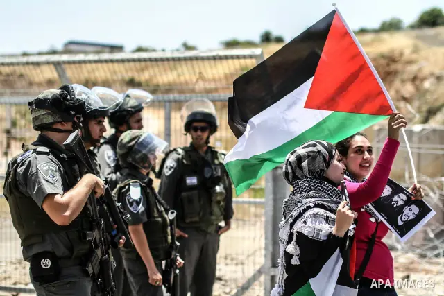 Female Palestinian protestors hold pictures of jailed Palestinian football player Mahmud Sarsak (R) and prisoners Akram Rikhawi (C) and Samir Al-Baraka during a demonstrating in front of Ofer prison, near the city of Ram...