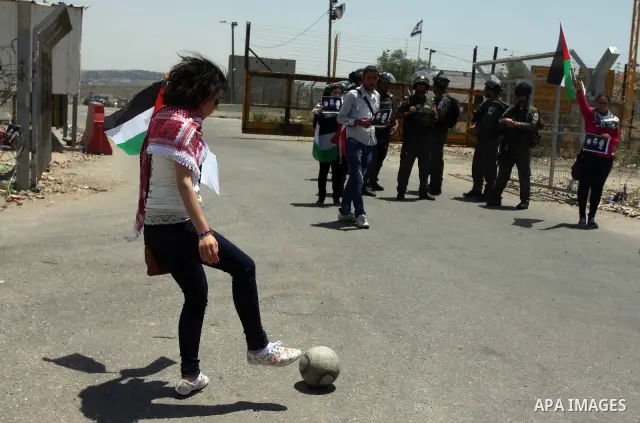 Israeli police keep guard as Palestinian protestors play football in front of Ofer prison, near the city of Ramallah, in solidarity with jailed Palestinian football player Mahmud Sarsak and prisoners Akram Rikhawi and Sa...