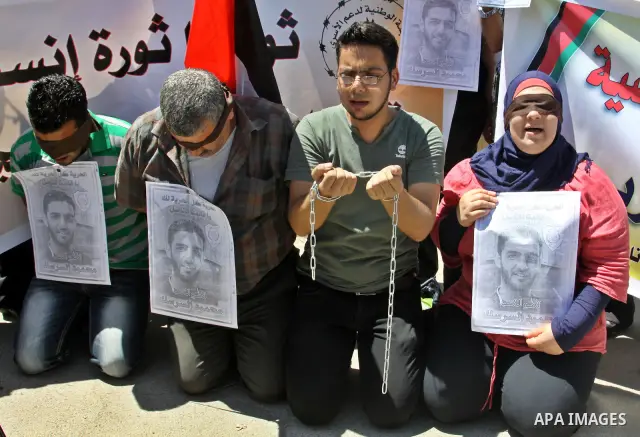 Palestinian protestors hold pictures of Palestinian prisoners Mahmoud Al-Sarsak and Akram al-Rikhawi, whose are still refusing food for 86 days after a deal was made to end a mass prisoner hunger strike, during a demonst...
