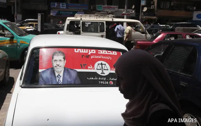 A poster of Egypt's Muslim Brotherhood candidate Mohammed Mursi is displayed in a car window in Cairo's al-Sayeda Zenab district on June 12, 2012. A few days before the second round of the historical elections between Mu...