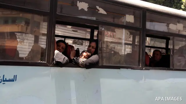 Egyptians rides bus in front of a defaced campaign election banners of presidential candidate and former prime minister Ahmed Shafik in Cairo June 12, 2012. The run-off on June 16 and 17 is the last stage in Egypt's firs...