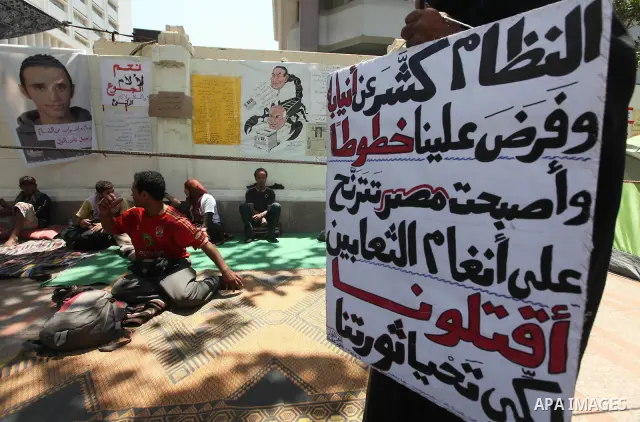 Protesters sit on the floor during a hunger strike in front of Egypt's cabinet office in Cairo on June 12, 2012. Around 60 activists are on the sixth day of a hunger strike demanding that former military man Ahmed Shafik...