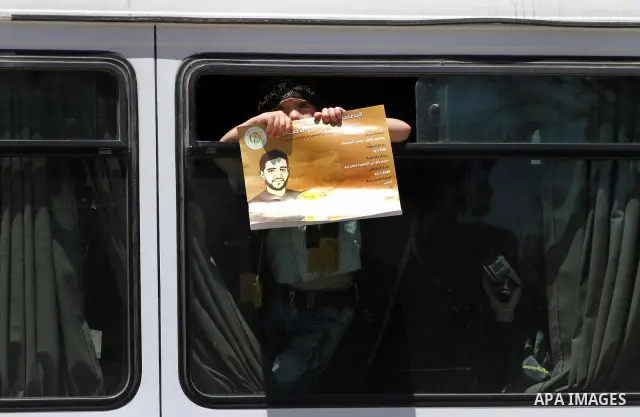 A Palestinian child holds a picture of Palestinian prisoners Mahmoud Al-Sarsak and Akram Al-Rikhawi, whose are still refusing food for 86 days after a deal was made to end a mass prisoner hunger strike, during a demonstr...