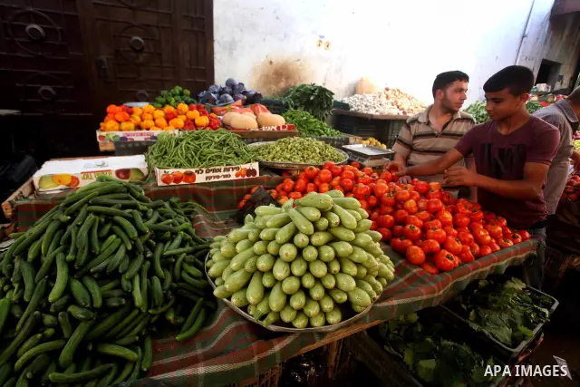 A Palestinian man buys vegetables and fruits in his shop at the popular AlZawya market in Gaza City on June. 12, 2012 . Photo by Ashraf Amra