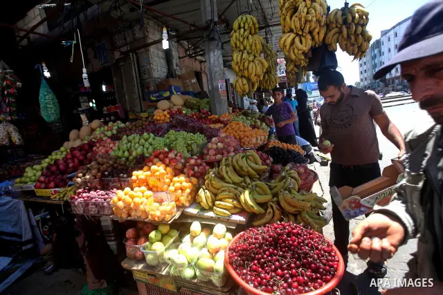 A Palestinian man buys vegetables and fruits in his shop at the popular AlZawya market in Gaza City on June. 12, 2012 . Photo by Ashraf Amra