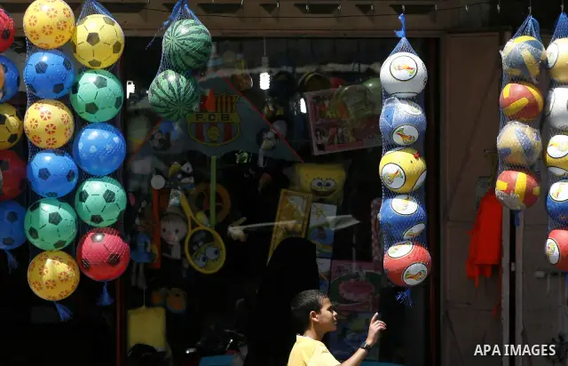 A Palestinian man stands in his games for shoes at market Rafah, southern Gaza city, on June 13, 2012. Photo by Eyad Al Baba
