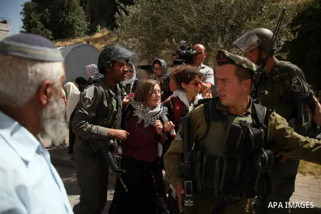Israeli soldiers and border police try to arrest a demonstrator wearing a traditional Palestinian dress during a demonstration on al-Shuhada street against the closure of the central street in the West Bank town of Hebro...