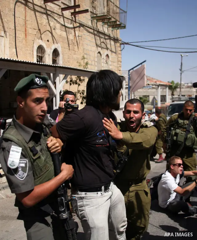 Israeli soldiers and border police try to arrest a demonstrator during a demonstration on al-Shuhada street against the closure of the central street in the West Bank town of Hebron, on June 13, 2012. The street is close...