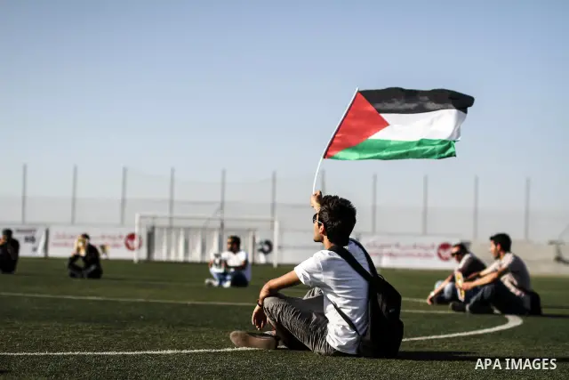 Palestinian athletes hold pictures and banners for prisoner Mahmoud Sarsak, a former player with the Palestinian national football team held in Israeli jails, during a protest calling for release him, at Al-Bireh playgro...