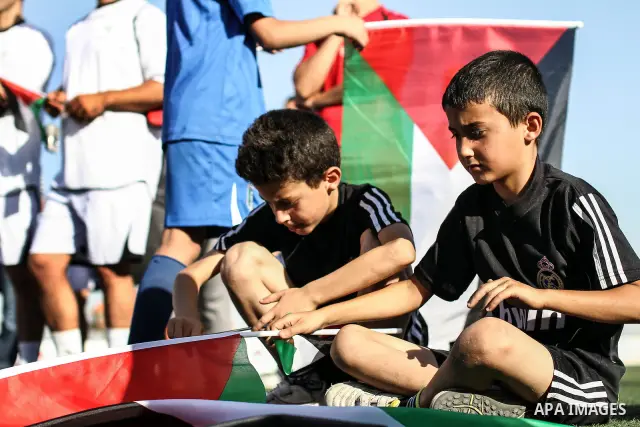 Palestinian athletes hold pictures and banners for prisoner Mahmoud Sarsak, a former player with the Palestinian national football team held in Israeli jails, during a protest calling for release him, at Al-Bireh playgro...