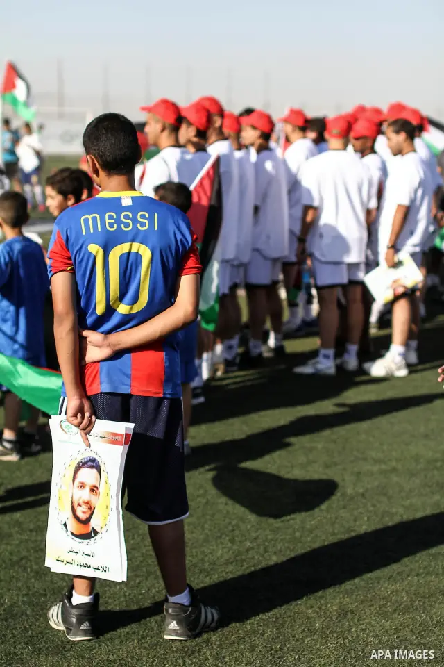 Palestinian athletes hold pictures and banners for prisoner Mahmoud Sarsak, a former player with the Palestinian national football team held in Israeli jails, during a protest calling for release him, at Al-Bireh playgro...