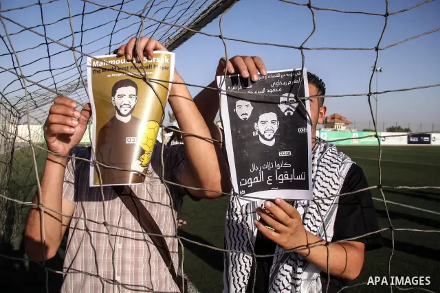 Palestinian athletes hold pictures and banners for prisoner Mahmoud Sarsak, a former player with the Palestinian national football team held in Israeli jails, during a protest calling for release him, at Al-Bireh playgro...