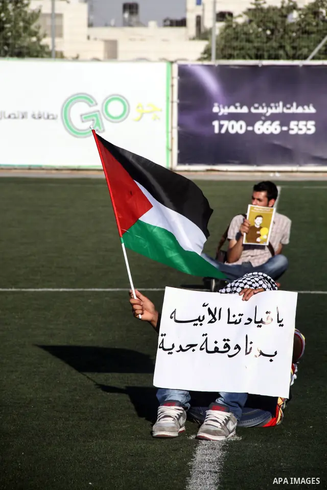 Palestinian athletes hold pictures and banners for prisoner Mahmoud Sarsak, a former player with the Palestinian national football team held in Israeli jails, during a protest calling for release him, at Al-Bireh playgro...