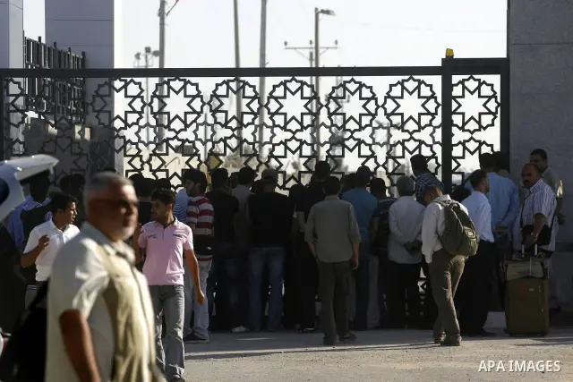 Palestinians load their luggage as they wait to cross into Egypt through the Rafah border crossing in the southern Gaza Strip on June 13, 2013. After the stopping of the Rafah border crossing from the Egyptian side Becau...