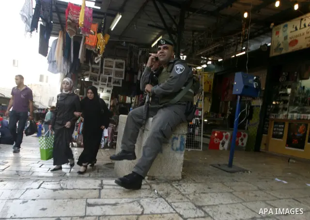 Israeli soldier sits at market in the old city of Jerusalem on 13 June 2012. FIFA president Sepp Blatter has expressed grave concern over reports that several Palestinian players have been illegally detained in Israel. P...