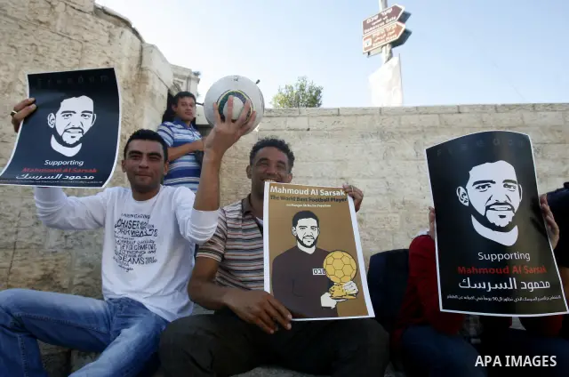 Palestinians hold posters depicting footballer Mahmoud Al-Sarsak, who is protesting his alleged illegal detention by Israel, during a rally in the old city of Jerusalem on June 13, 2012. FIFA president Sepp Blatter has e...